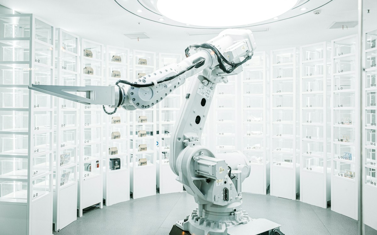 Otomatik depoda çalışan endüstriyel robot kol — süreç otomasyonu